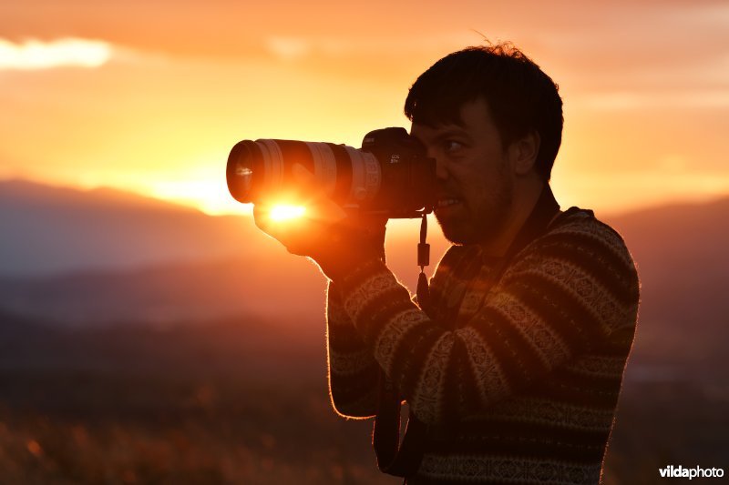 Natuurfotograaf bij zonsondergang 