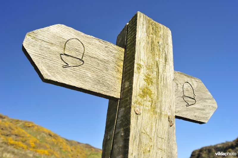 Bewegwijzerde wandelroute op het strand van Wales